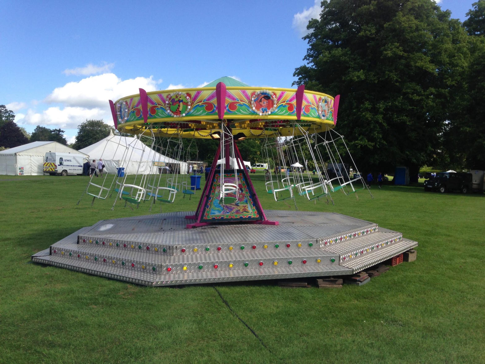 Chair-o-planes on the grass at a travelling ground